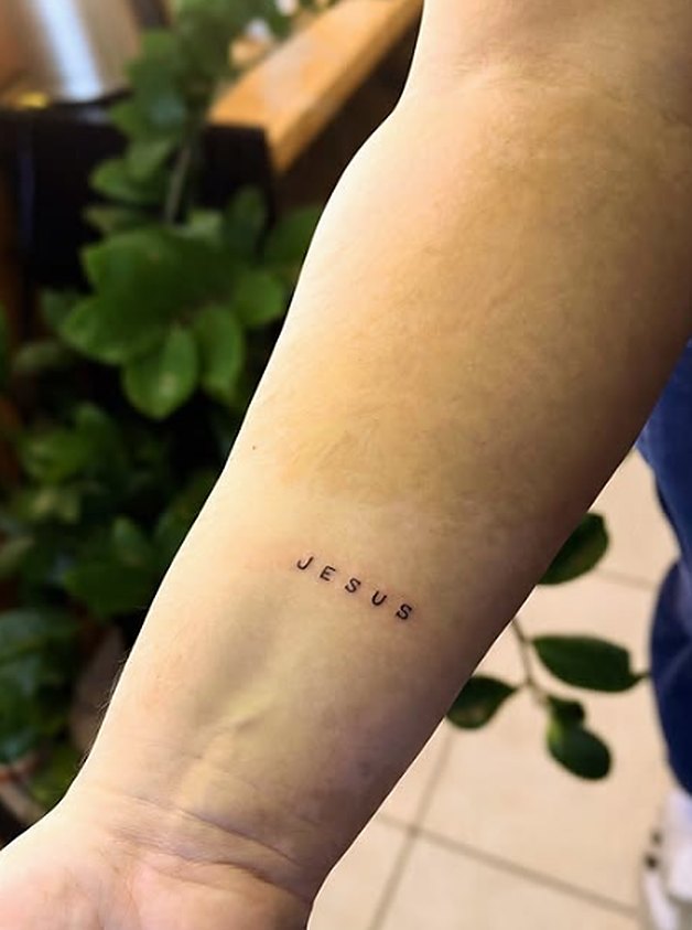 Palavra Jesus em letras finas no pulso