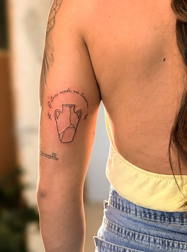 Jarro com frase em fineline no braço