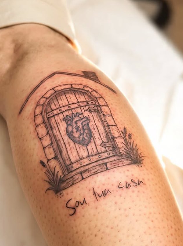 Tatuagem fineline de uma porta com coração e a frase Sou tua casa